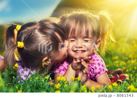 happy girls twin sisters kissing and laughing in the summer outd 8061543