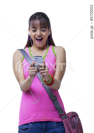 Surprised young college girl listening music over white background 8070002