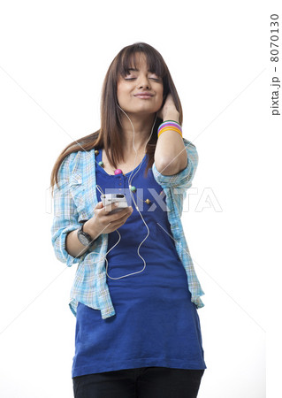 Young woman listening music while closing eyes over white background 8070130