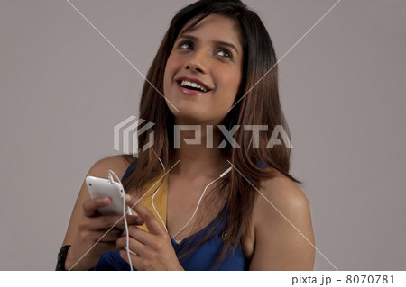 Woman listening to music on her phone Woman listening to music on her phone 8070781