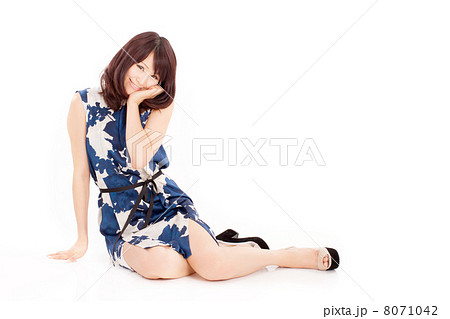 足を崩して可愛らしいポーズで座る夏服を着た代の女の子の写真素材