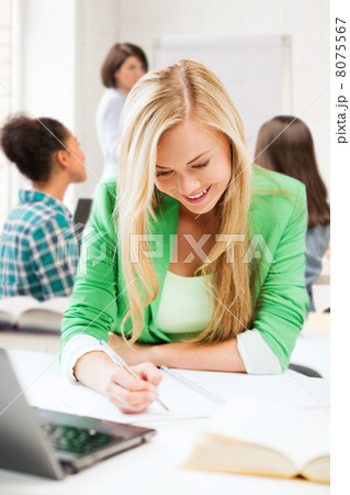 student girl writing in notebook at school 8075567
