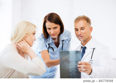 doctors with patient looking at x-ray doctors with patient looking at x-ray 8075698