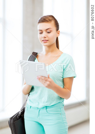 smiling student with tablet pc in college 8076602