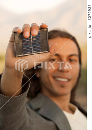 Handsome young man with small solar panel 8076988