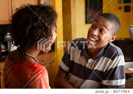 African-American woman and teen laugh in kitchen 8077064