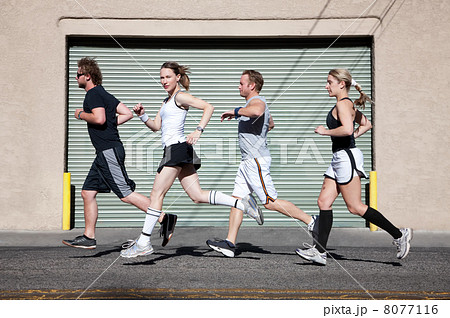 Foursome runs in the city for exercise. Foursome runs in the city for exercise. 8077116