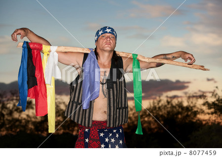 Indigenous man with ceremonial pole 8077459