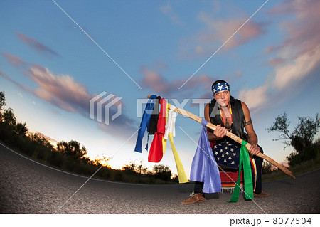 Indigenous man in the middle of a road with ceremonial pole and 8077504
