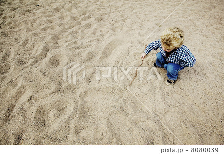 Little Boy Drawing in the Sand 8080039