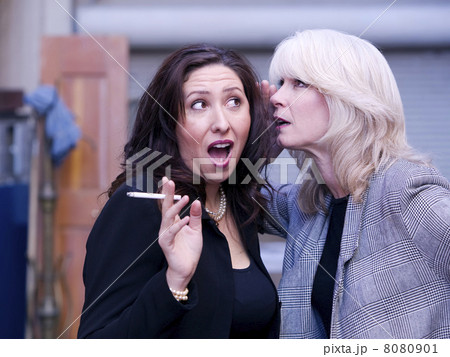 Women Gossip During a Smoking Break 8080901