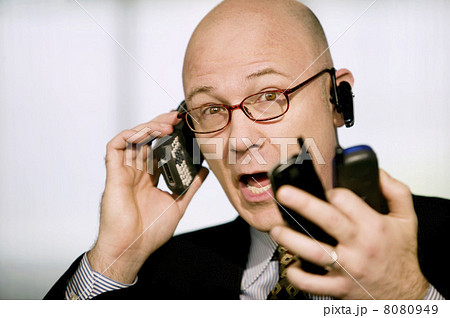 Businessman with multiple cell phones Businessman with multiple cell phones 8080949