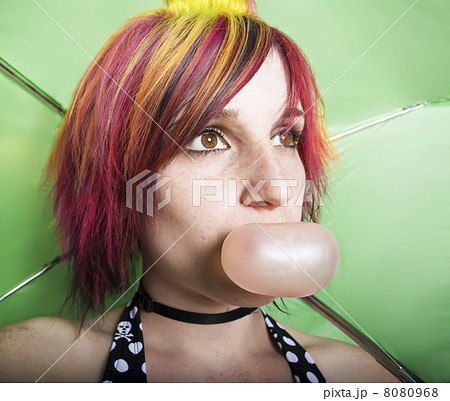 Pretty Woman with a Green Umbrella Blowing a Bubble 8080968