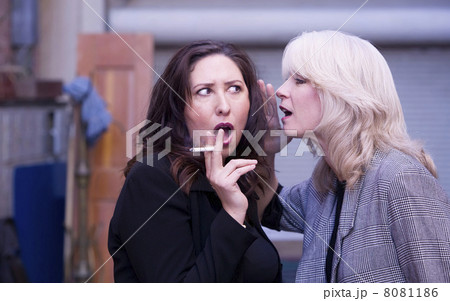 Women Gossip During a Smoking Break 8081186