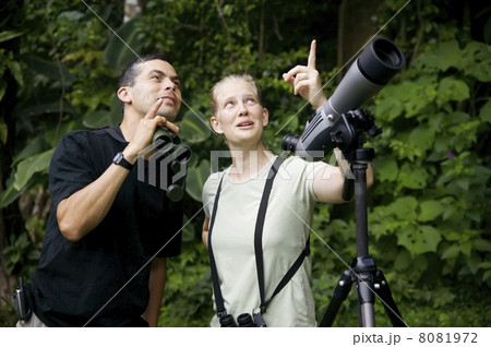 Pretty Woman with Binoculars and Man with Telescope in Jungle Pretty Woman with Binoculars and Man with Telescope in Jungle 8081972