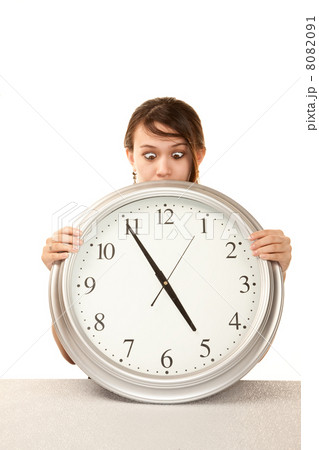 Woman at work holding large clock Woman at work holding large clock 8082091