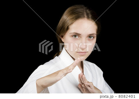 Young girl in a karate pose on black 8082401