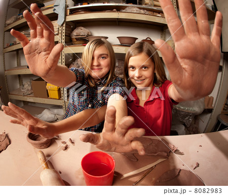 Cute young girls in a clay studio holding up their hands Cute young girls in a clay studio holding up their hands 8082983