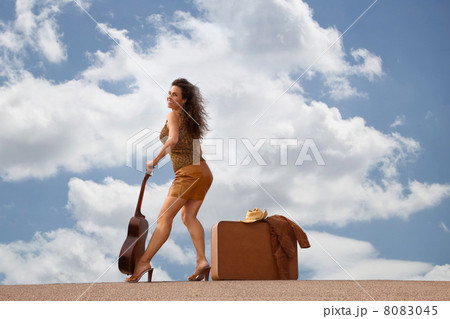 Pretty woman with suitcase and guitar 8083045