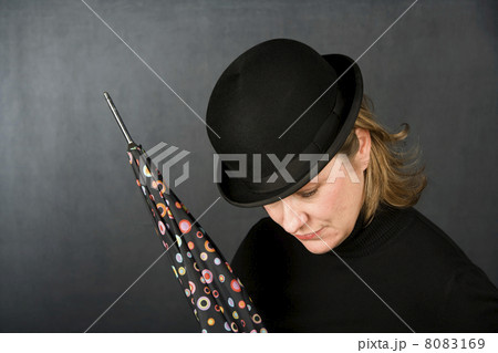 Woman in a bowler hat with umbrella Woman in a bowler hat with umbrella 8083169