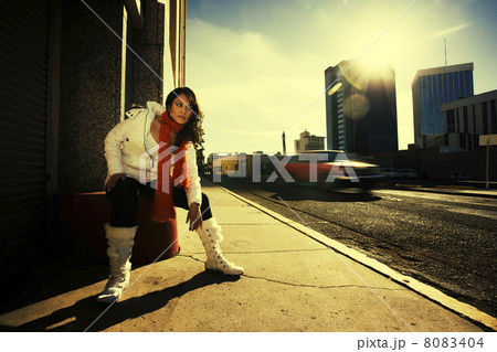 Pretty woman at sundown in city 8083404