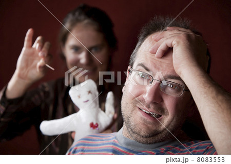 Upset woman with vioodoo doll and guilty man 8083553