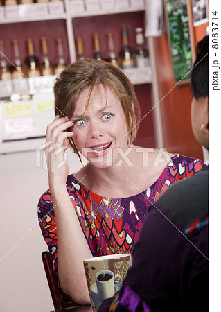 Appalled woman in coffee house with male friend Appalled woman in coffee house with male friend 8083714
