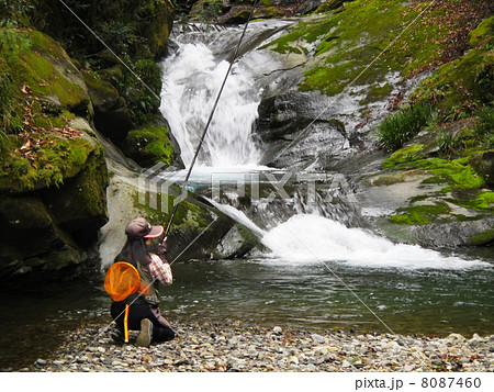 渓流釣りをする女性の写真素材