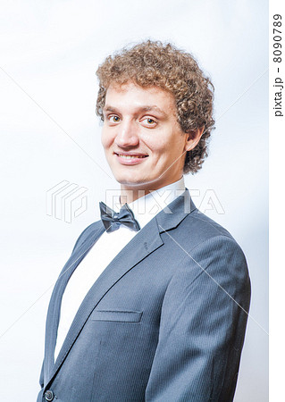 smiling curly man in black and bow tie 8090789