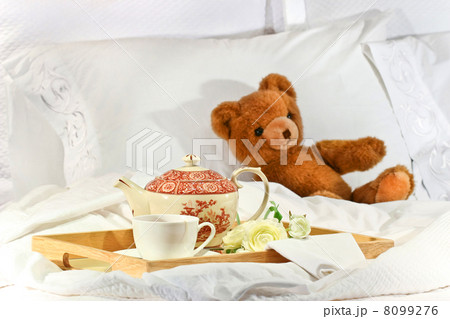 Tea in bed with teddy on white sheets 8099276