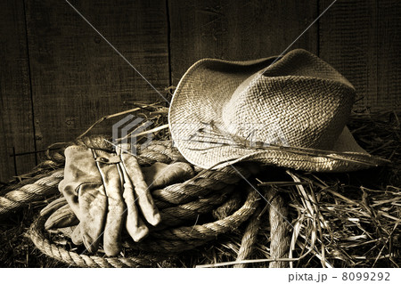 Straw hat with gloves on a bale of hay Straw hat with gloves on a bale of hay 8099292