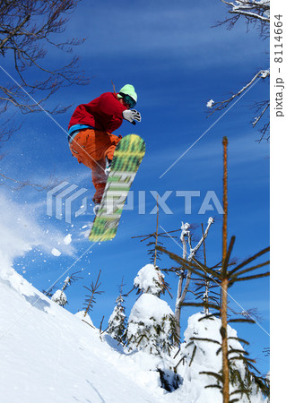 Snowboarder jumping against blue sky Snowboarder jumping against blue sky 8114664