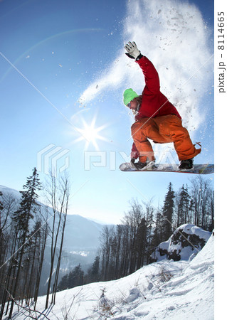 Snowboarder jumping against blue sky Snowboarder jumping against blue sky 8114665