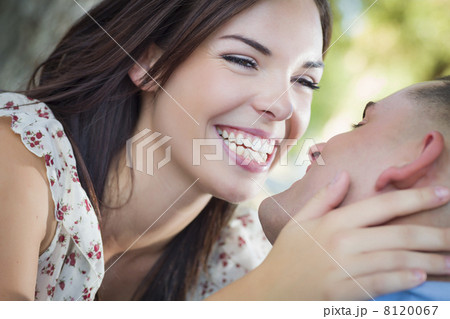 Mixed Race Romantic Couple Kissing in the Park 8120067