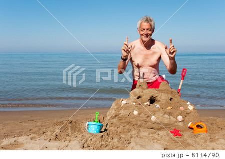 Elderly man with sand castle Elderly man with sand castle 8134790