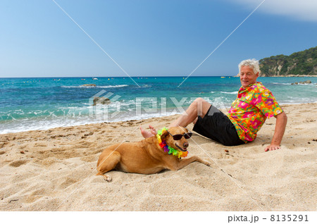 man laying with dog at the beach man laying with dog at the beach 8135291