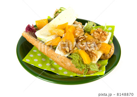 Bread roll with French cheese on green plate 8148870