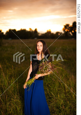 Beautiful woman in long dress holding bouquet of wild flowers Beautiful woman in long dress holding bouquet of wild flowers 8152751