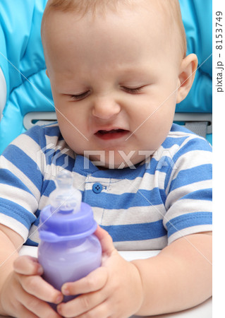 baby with milk bottle unhappy 8153749