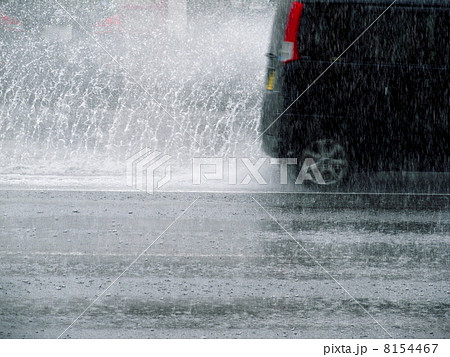 豪雨の中の車の水はねの写真素材