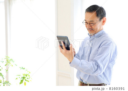タブレットPCを使うシニア男性 8160391