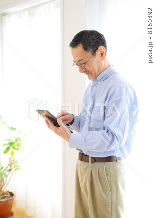 タブレットPCを使うシニア男性 8160392