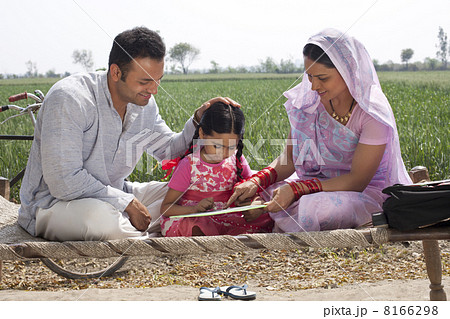 Indian mother and father helping daughter with her homework 8166298