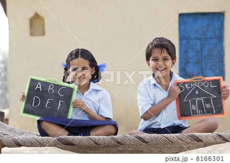Portrait of happy children in school uniform holding a slate 8166301