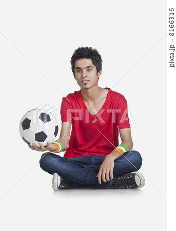 Portrait of young boy in casual wear holding soccer ball over white background 8166316