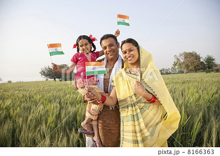 Portrait of a rural family holding an Indian flag 8166363
