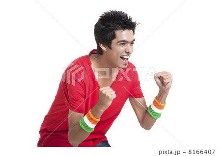 Excited young boy looking away while cheering with clenched fists over white background 8166407