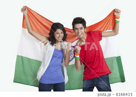 Portrait of happy young friends cheering while holding Indian flag over white background 8166415