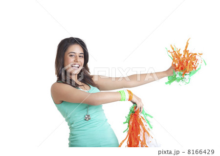 Portrait of happy young female holding out tricolor pom poms over white background 8166429