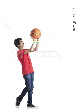 Full length of young boy in casuals aiming basketball over white background Full length of young boy in casuals aiming basketball over white background 8166466